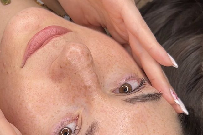 Viso disteso durante un trattamento, con le mani appoggiate sulle tempie